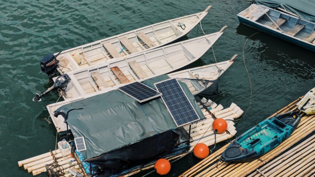 Boote mit Solarpaneelen an einem schwimmenden Holzsteg