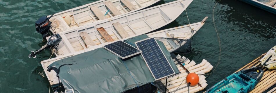 Boote mit Solarpaneelen an einem schwimmenden Holzsteg