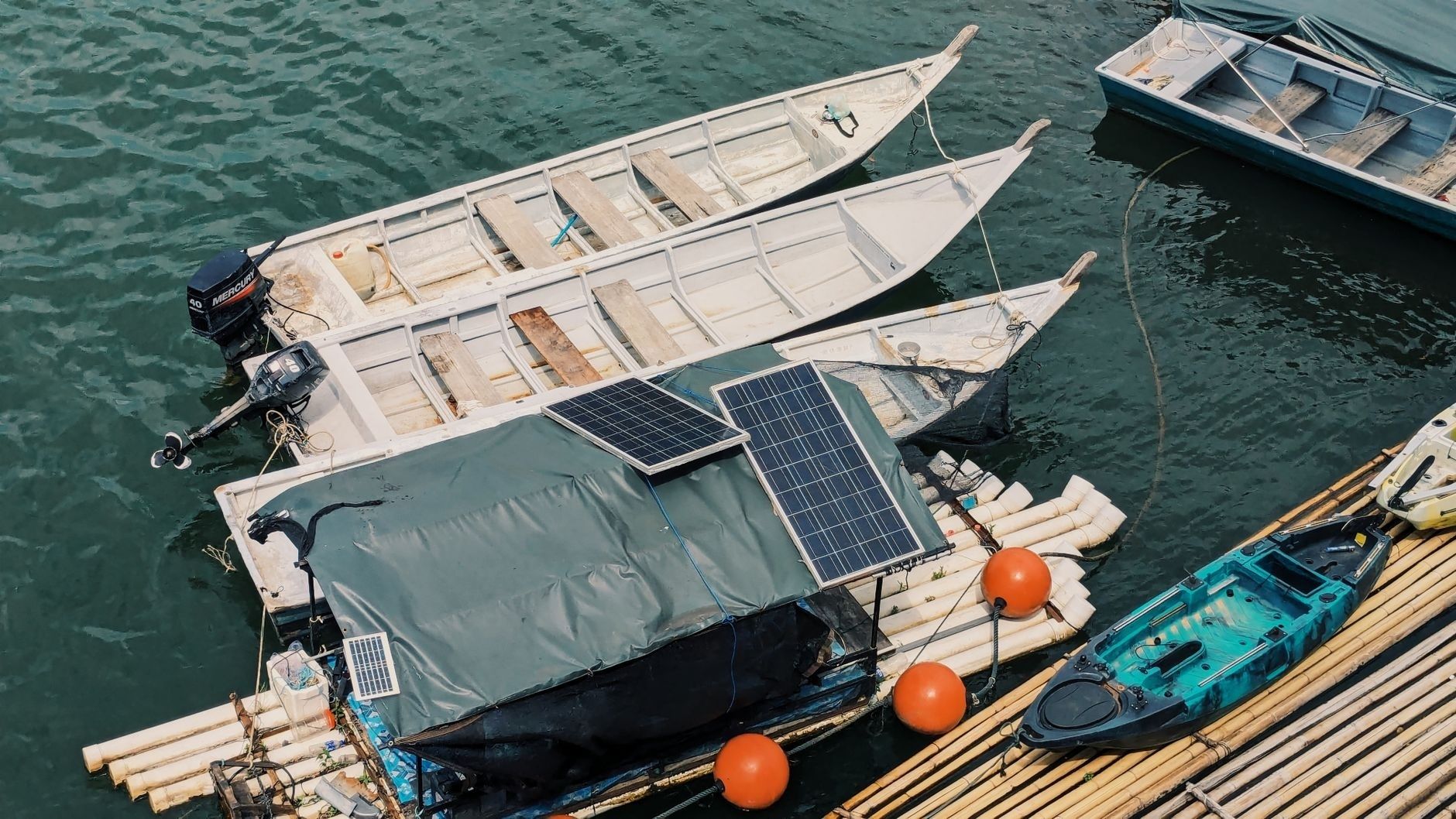 Boote mit Solarpaneelen an einem schwimmenden Holzsteg